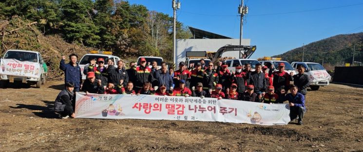 가평군이 관내 취약계층 12가구에 1t 트럭 12대 분량의 겨울철 난방용 땔감을 지원한 뒤 기념촬영을 하고 있다. 가평군 제공