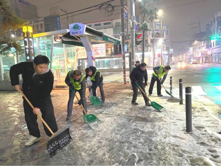 강북구 재난도우미들이 겨울철 주민들의 안전한 보행을 위해 거리에 쌓인 눈과 얼음을 치우고 있다. 강북구 제공.