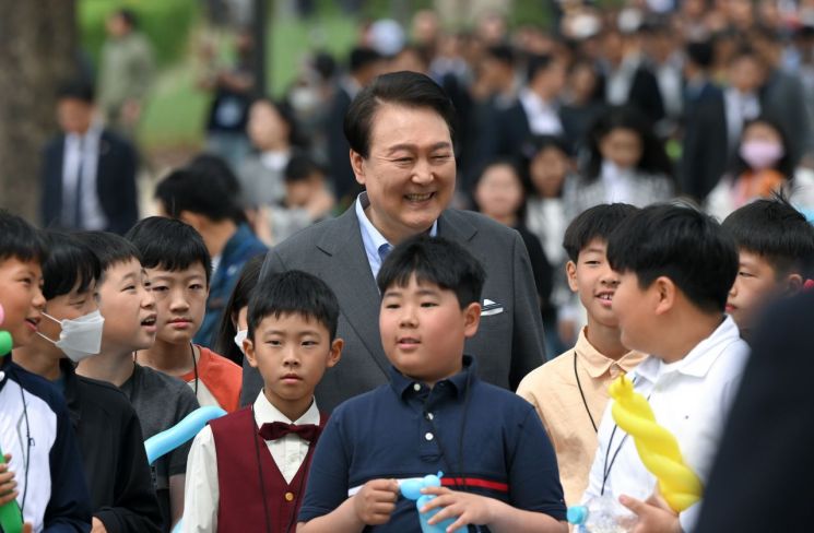 윤석열 대통령이 4일 서울 용산 대통령실의 앞마당에 조성된 용산 어린이정원 개방행사에서 어린이들과 함께 환하게 웃고 있다. [대통령실통신사진기자단]