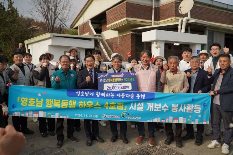 경북개발공사와 전남개발공사 직원들이 전남 담양군 고서면의 낡은 주택을 수리한 '영호남 행복동행하우스 4호점' 을 준공한 뒤 집앞에서 기념촬영을 하고 있다.