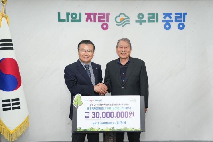 左侧的中浪区厅厅长 Ryu Gyeonggi 从上凤2洞孝爱奉仕会顾问 Jang Guibong 手中接过“我的植树事业”捐款3000万韩元。