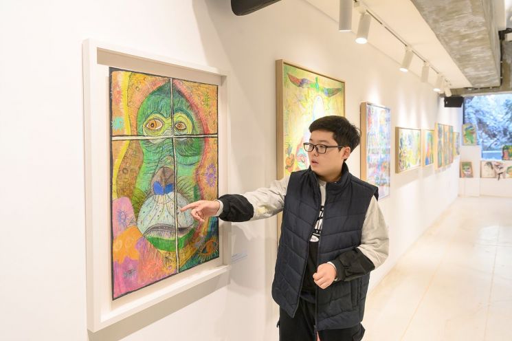 在发育障碍画家Yang Yejun的个人展上，画家Yang Yejun正在讲解自己的作品。阳川区提供。
