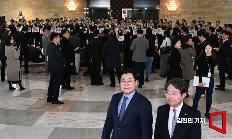 박찬대 더불어민주당 원내대표 등이 2일 국회 본회의장으로 입장하고 있다. 뒤로는 국민의힘 의원들이 민주당의 감사원장 탄핵안 보고를 규탄하는 피켓시위를 하고 있다. 김현민 기자