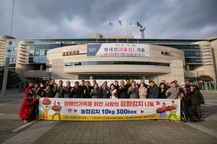 양주시장애인체육회가 5일 시청광장에서 장애인 가족들을 위한 ‘사랑의 김장 김치 전달식’을 진행한 뒤 기념촬영을 하고 있다. 남양주시 제공