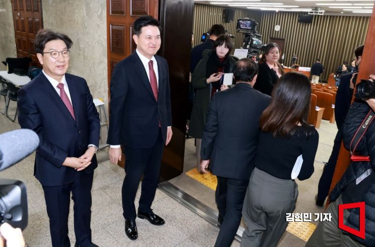 국민의힘 원내대표 후보인 권성동 의원(왼쪽)과 김태호 의원이 12일 국회에서 열린 원내대표 선출을 위한 의원총회장 앞에서 참석 의원들과 인사하고 있다. 김현민 기자