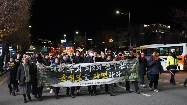 12일 오후 광주 동구 금남로 일대에서 천주교광주대교구 정의평화위원회 신부와 수녀, 신자들이 '내란 수괴 제2의 전두환, 윤석열을 파면하라', '내란수괴 윤석열 즉각 탄핵’이 적힌 피켓과 야간봉을 들고 행진을 하고 있다. 송보현 기자