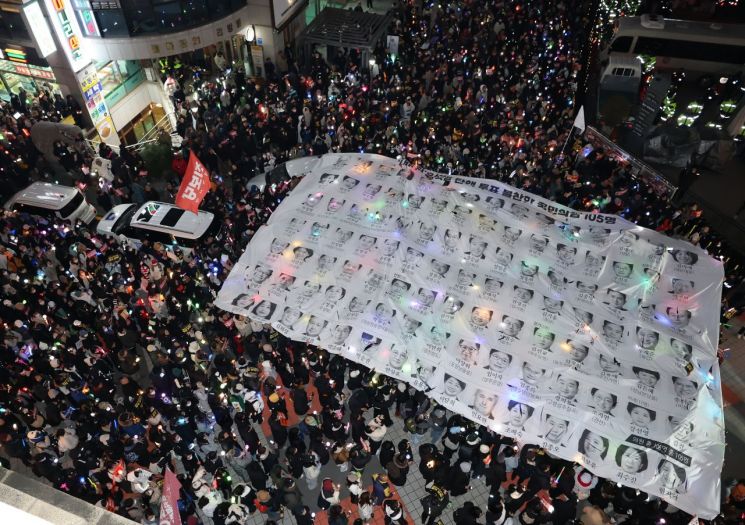 지난 12일 서울 영등포구 국민의힘 당 사무실 앞에서 열린 윤석열 대통령 탄핵 촉구 촛불 집회 행진에 참석한 시민들이 윤 대통령의 탄핵소추안 투표에 불참한 국민의힘 원들을 규탄하고 있다. 연합뉴스