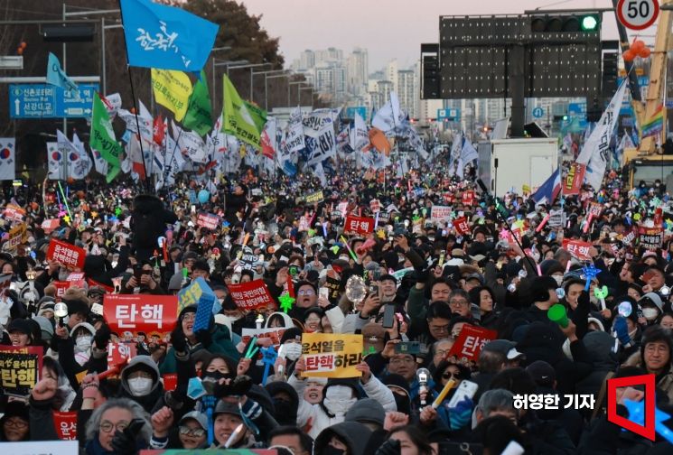 윤석열 대통령에 대한 2차 탄핵 표결에서 탄핵소추안이 가결된 후 서울 여의도 국회의사당 앞에 운집한 집회 참가자들이 환호하며 춤을 추고 있다. 허영한 기자