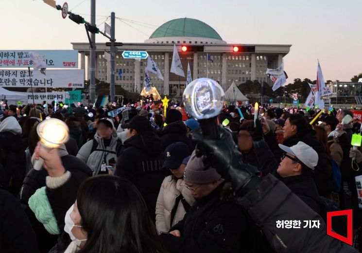 윤석열 대통령에 대한 2차 탄핵 표결에서 탄핵소추안이 가결된 후 서울 여의도 국회의사당 앞에 운집한 집회 참가자들이 환호하며 춤을 추고 있다. 허영한 기자