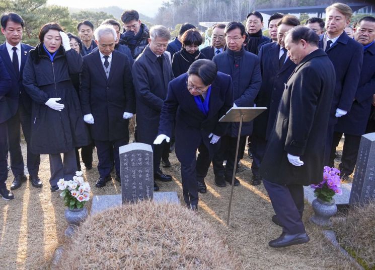 강기정 광주시장이 16일 오전 북구 운정동 국립 5·18민주묘지를 찾아 소설 ‘소년이 온다’ 주인공 ‘동호’의 실제 인물인 문재학 열사의 묘비를 어루만지고 있다. 광주시 제공