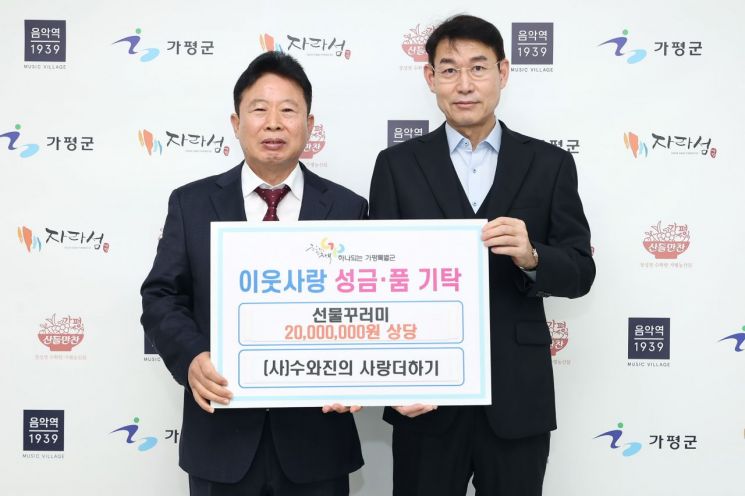 서태원 군구(왼쪽)이 지난 23일 ㈔수와진의 사랑더하기로부터 2000만원 상당의 산타선물세트를 기탁받아 이웃돕기 성품 전달식을 진행하고 있다. 가평군 제공