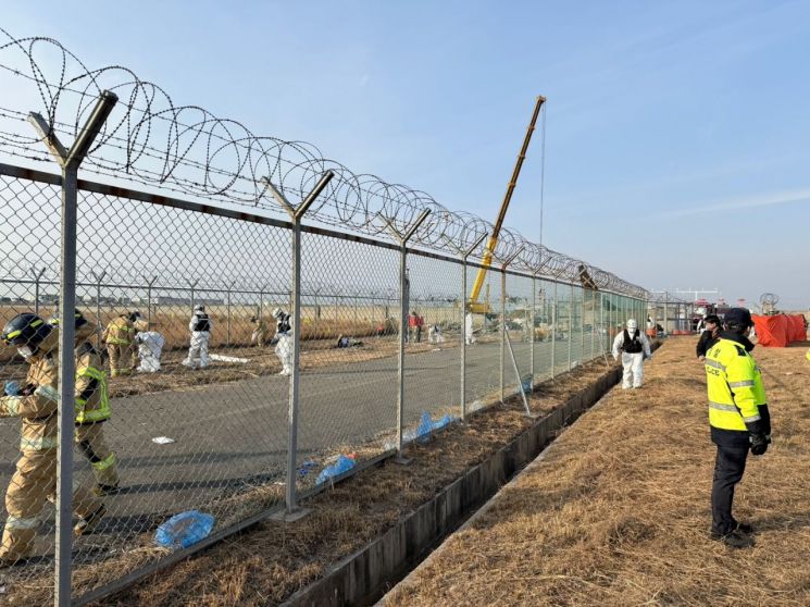 29일 오후 전남 무안국제공항 항공기 추락사고 현장에서 경찰과 소방당국이 활주로 등에 떨어진 시신과 물체 등을 수습하고 있다. 서영서 기자