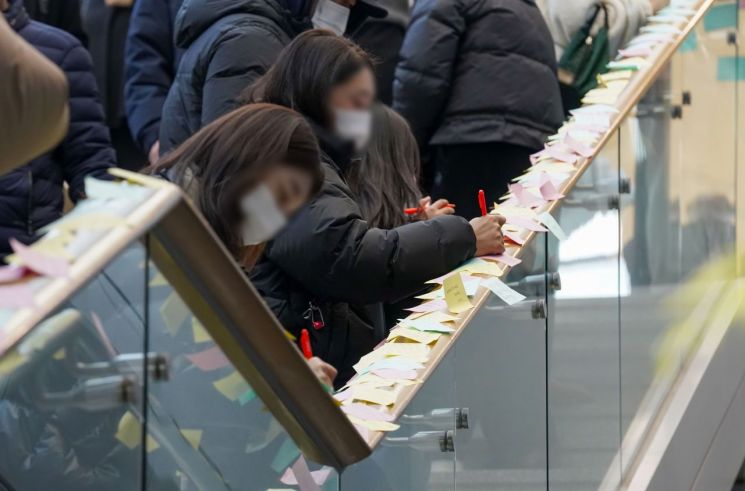 1일 전남 무안국제공항 여객터미널 1층 계단에서 시민들이 추모 메시지를 남기고 있다. 연합뉴스