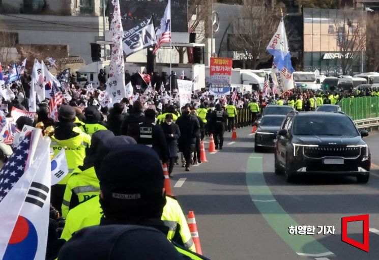 3일 윤석열 대통령 관저에서 체포영장 집행에 나섰던 공수처 관계자들이 5시간 넘게 경호처와 대치한 끝에 집행을 중지하고 철수했다. 관저 부근 윤 대통령 지지자들이 집회를 하고 있는 옆으로 공수처 직원들이 타고 온 차량들이 지나가고 있다. 사진=허영한 기자