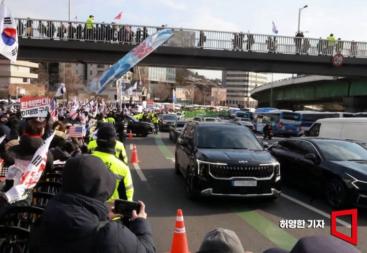 지난 3일 윤석열 대통령 관저에서 체포영장 집행에 나섰던 공수처 관계자들이 5시간 넘게 대통령경호처와 대치한 끝에 집행을 중지하고 철수했다. 관저 부근 윤 대통령 지지자들이 집회를 하고 있는 옆으로 공수처 직원들이 타고 온 차량들이 지나가고 있다. 허영한 기자