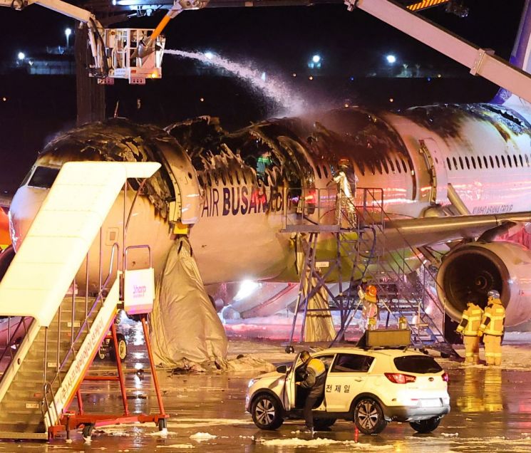 28일 오후 김해공항 계류장에서 승객 170명과 승무원 6명을 태우고 이륙을 준비하던 홍콩행 에어부산 항공기 BX391편 내부에서 불이 나 소방대원들이 진화 작업을 하고 있다. 사진출처=연합뉴스