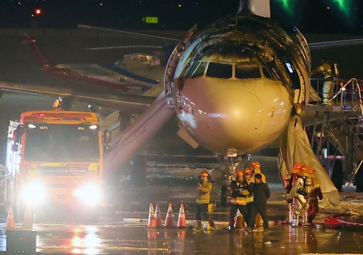 28일 오후 김해공항 계류장에서 승객 170명과 승무원 6명을 태우고 이륙을 준비하던 홍콩행 에어부산 항공기 BX391편 내부에서 불이 나 소방대원들이 진화 작업을 하고 있다. 여객기 왼쪽에 에어슬라이드가 펼쳐져 있다. . 사진출처=연합뉴스