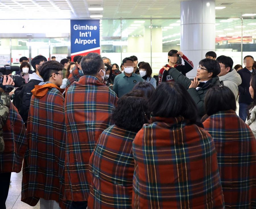 29日，在釜山江西区金海国际机场，搭乘发生火灾的Air Busan客机的乘客接过航空公司发放的毛毯并听取说明。28日晚上10时26分左右，一架载有170名乘客和6名机组人员、准备从金海机场停机坪起飞前往香港的Air Busan BX391次航班机舱内起火。火灾在1小时16分钟后被完全扑灭，170名乘客（包括1名随机维修师）和6名机组人员在内的共176人全部通过紧急滑梯撤离。联合通讯社供图