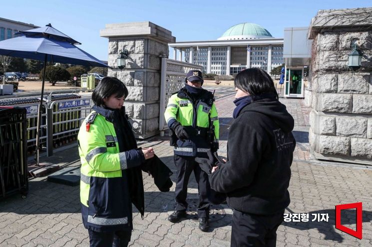 81기동대 김민주 경장이 5일 서울 여의도 국회 앞에서 근무를 서기 위해 방한장구를 착용 하고 있다. 강진형 기자