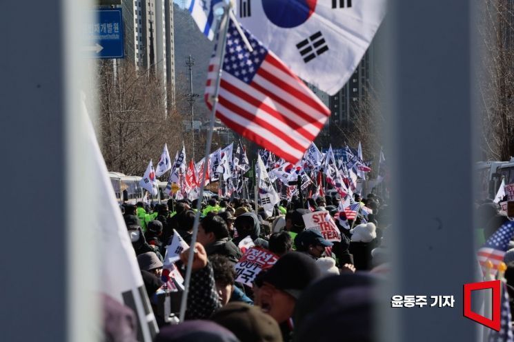 윤석열 대통령 2차 체포영장 집행이 진행된 지난 15일 과천청사 공수처 청사 앞에 윤 대통령 지지자들이 태극기와 성조기를 들고 모여있다.
