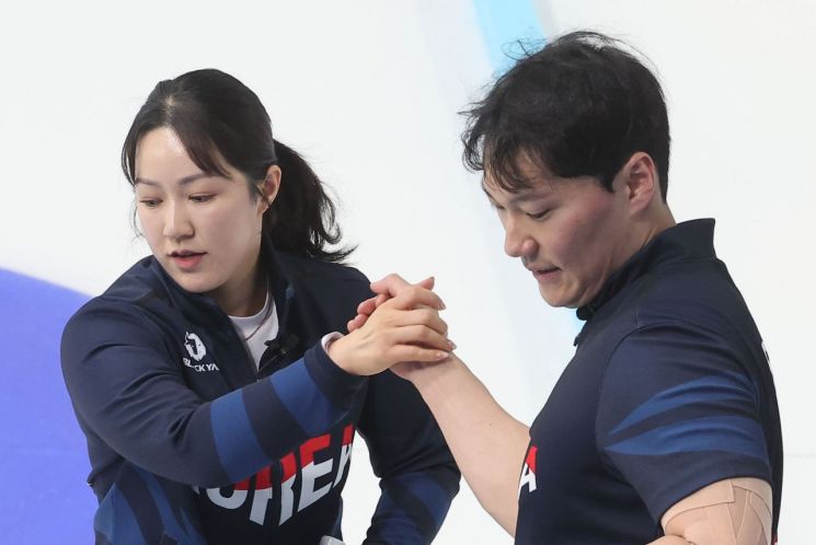 컬링 대표팀 김경애-성지훈 조가 6일 중국 하얼빈 핑팡 컬링 아레나에서 열린 컬링 믹스더블 라운드로빈 B조 중국과의 경기에서 서로를 격려하고 있다.   [사진 제공= 연합뉴스]