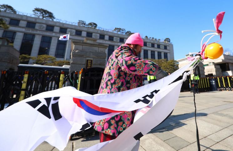 윤석열 대통령 지지자가 서울 종로구 헌법재판소 앞을 지나고 있다. 연합뉴스