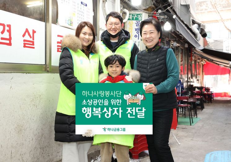 8일 명동상인연합회와 함께 지역사회 소상공인을 위한 봉사활동을 실시한 하나금융 임직원과 가족들이 지역 소상공인(사진 왼쪽에서 네 번째)과 기념촬영을 하고 있다. [사진제공=하나금융]