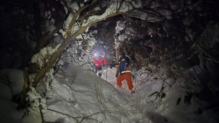 소방대원들이 눈 쌓인 산에 고립된 등산객을 구조해 산을 내려오고 있다. 경남소방본부 제공