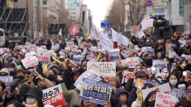 지난해 12월 14일 광주 동구 금남로 특설무대에서 열린 6차 광주시민 총궐기대회에 참석한 시민들이 손팻말을 든 채 환호하고 있다. 송보현 기자