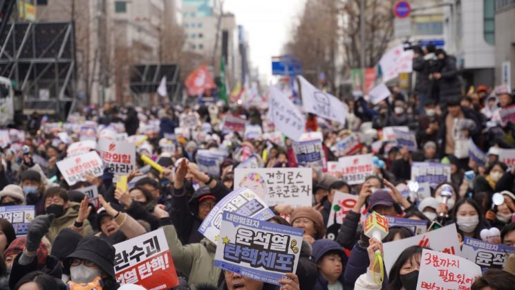 지난해 12월 14일 광주 동구 금남로 특설무대에서 열린 6차 광주시민 총궐기대회에 참석한 시민들이 손팻말을 든 채 환호하고 있다. 송보현 기자