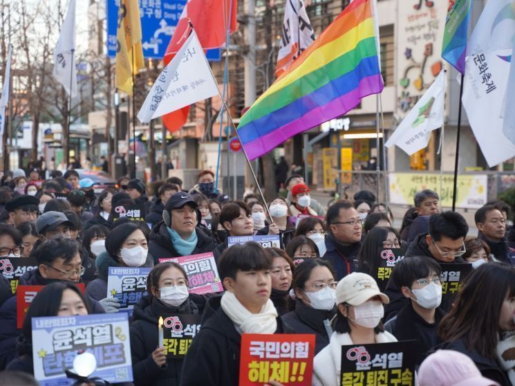 지난해 12월 14일 광주 동구 금남로 특설무대에서 열린 6차 광주시민 총궐기대회에 참석한 시민들이 손팻말을 든 채 환호하고 있다. 송보현 기자