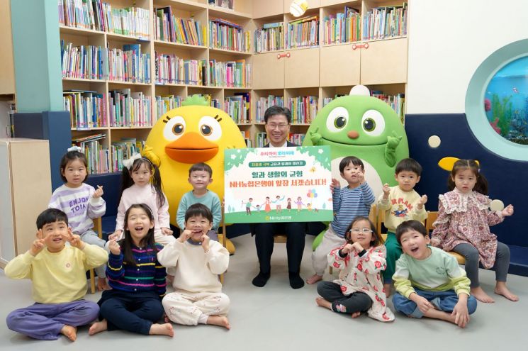 강태영 NH농협은행장이 서울 중구에 위치한 사내 어린이집에서 아이들과 함께 저출생 위기 극복 릴레이 챌린지 사진촬영을 하고 있다. NH농협은행 제공