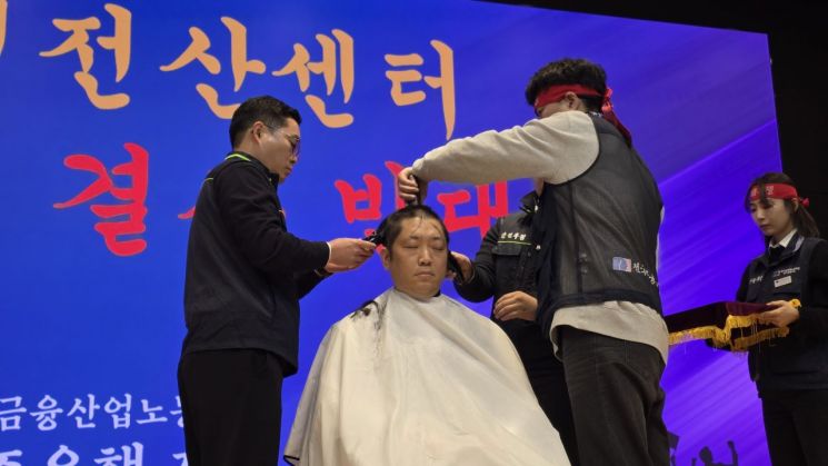 19일 광주은행 3층에서 열린 광주은행 전산센터 전북이전 결사반대 대의원대회에서 전국금융산업노동조합 광주은행지부 조합원들이 삭발식을 거행하고 있다. 민찬기 기자