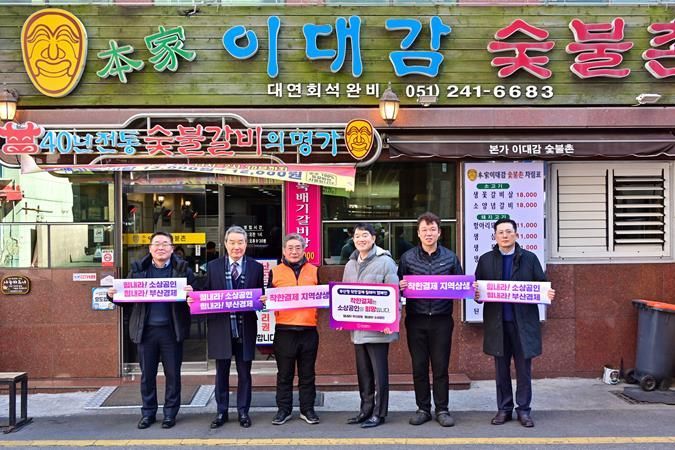 우양수산 조영준 대표(오른쪽에서 3번째)와 직원 등이 착한결제 캠페인에 참여해 피킷 홍보물을 들고 있다.