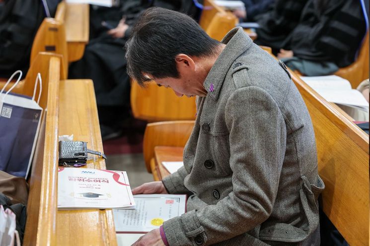 20일 목원대 ‘2024학년도 전기 학위수여식’에서 故 박가영 씨의 아버지가 고개를 숙인 채 딸의 명예졸업 증서를 바라보고 있다. 목원대 제공
