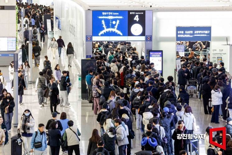 임시공휴일이 포함된 설 명절 연휴를 앞둔 지난달 24일 인천국제공항 제1여객터미널을 찾은 여행객들이 탑승동으로 이동하기 위해 줄을 서고 있다.