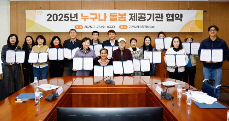이천시 '누구나 돌봄' 서비스 제공기관 관계자들이 협약식에서 협약서를 들어보이고 있다. 이천시 제공