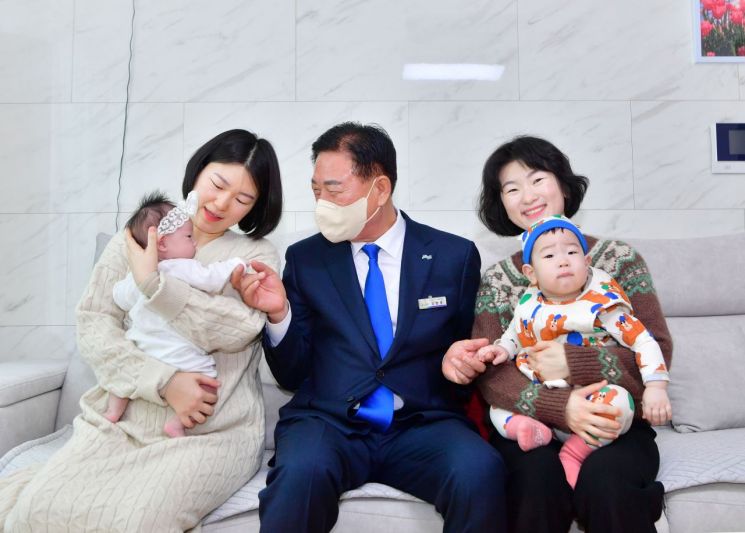 김한종 장성군수(가운데)가 지난달 28일 지역 내 엄마·아기 가정을 방문해 감사 인사를 전하고 있다. 장성군 제공