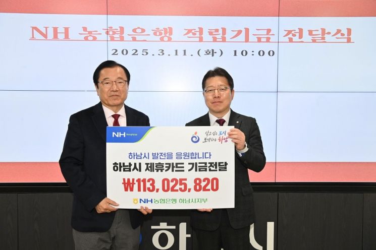 이석표 NH농협은행 하남시지부장이 지난 11일 이현재 시장(왼쪽)에게 제휴카드  이용으로 발생한 적립기금 1억1302만5820원을 전달한고 있다. 하남시 제공