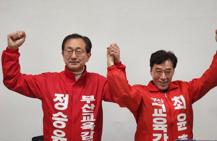 정승윤 후보와 최윤홍 후보가 단일화 합의를 하고 손을 올리고 있다.
