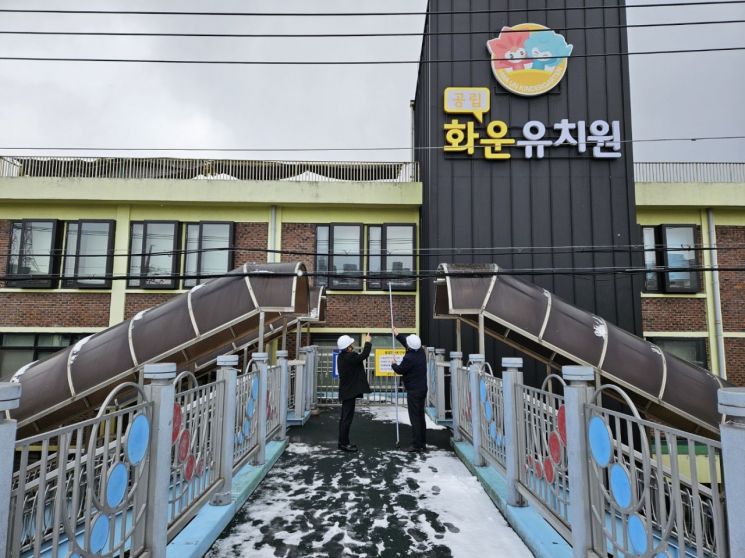 광주 화운유치원 앞 육교에서 전선과 육교 거리를 측정하고 있는 시교육청 직원들. 광주교육청 제공