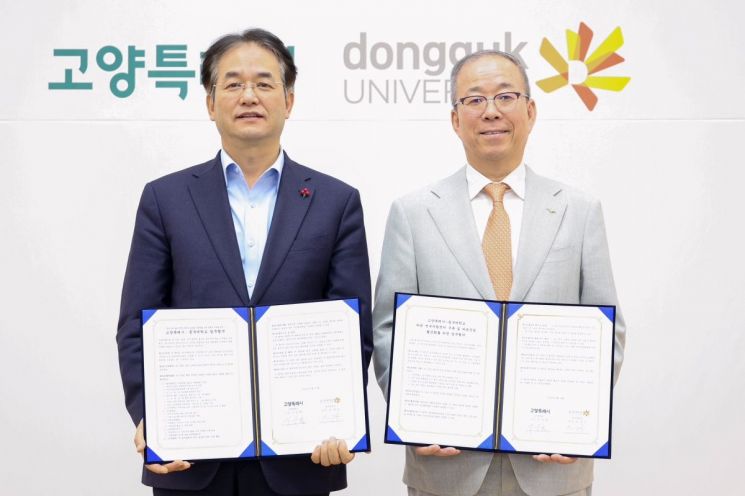 이동환 고양특례시장(왼쪽)과 윤재웅 동국대학교 총장이 지난 18일 고양특례시-동국대학교 업무협약을 체결한 후 협약서를 들고 기념사진을 찍고 있다. 고양특례시 제공