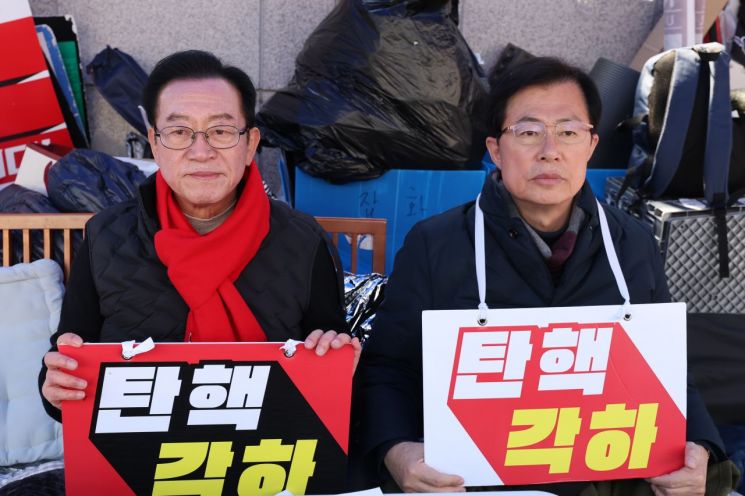 국민의힘 이종배(왼쪽), 이만희 의원이 19일 서울 종로구 헌법재판소 앞에서 윤석열 대통령의 탄핵 각하를 촉구하는 릴레이 시위를 하고 있다. 연합뉴스