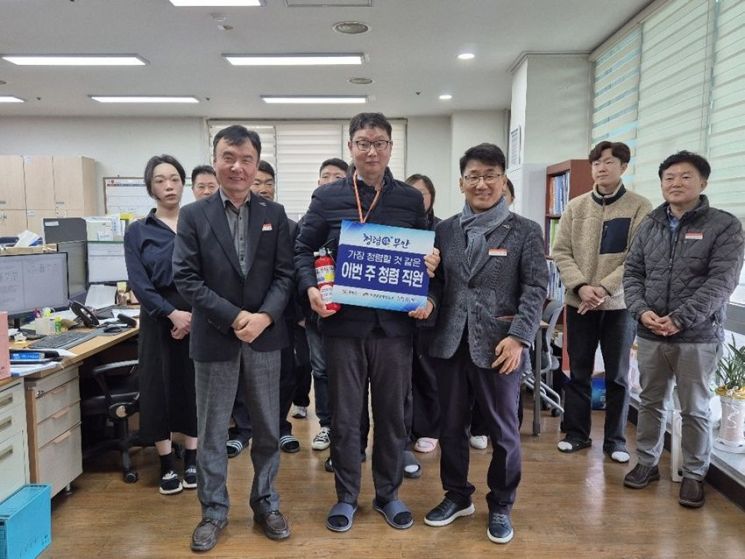 (우측)강건선 기획실장이 이번 주 청렴직원에게 청렴 피켓과 청렴 소화기를 전달하고 기념 촬영을 하고 있다. 무안군 제공