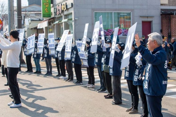 정철원 담양군수 재선거 조국혁신당 후보가 20일 창평시장에서 연설하고 있는 가운데 선거운동원들이 피켓을 들고 응원하고 있다. 정철원 후보 제공