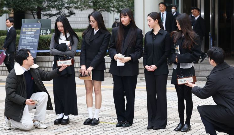 걸그룹 뉴진스(NJZ)가 7일 서울 서초구 서울중앙지방법원에서 열린 '기획사 지위보전 및 광고계약 체결 등 금지' 가처분 신청의 심문기일을 마친 뒤 법원 청사를 나서며 취재진 질문에 답하고 있다. 연합뉴스