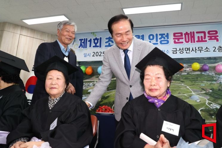 경북 의성군제1회 초등학교 인정 문해교육 졸업식에서 김주수 군수가 졸업생과 환하게 미소 짓고 있다.