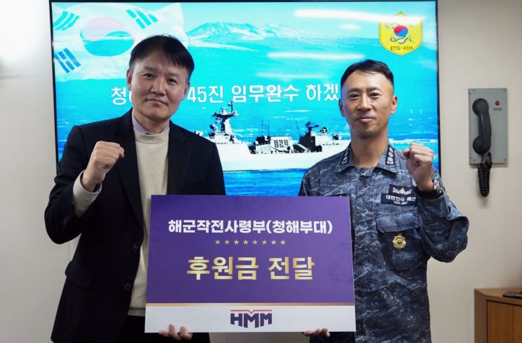 지난 21일 환송 행사에 참석한 HMM 관계자(왼쪽)가 청해부대에 후원금을 전달하고 있다. HMM 제공