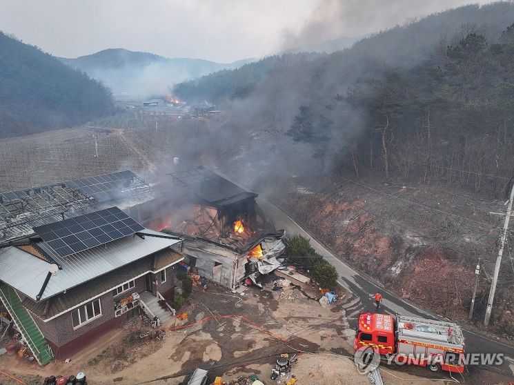 22일 경북 의성군 안평면 괴산리에서 발생한 산불이 급격하게 확산하는 가운데 한 주택 건물이 산불이 옮겨붙어 소실돼 있다. 연합뉴스