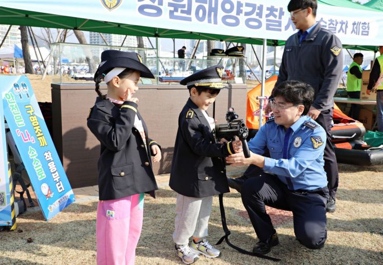 3.15마라톤대회에서 운영한 창원해경 해양안전캠페인 부스에서 어린이들이 해양경찰 제복을 입어보고 있다. 창원해양경찰서 제공